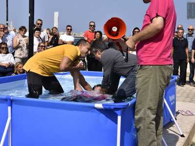 ...si lasciano cadere all�indietro affidandosi alle braccia del pastore e immergendosi completamente in acqua